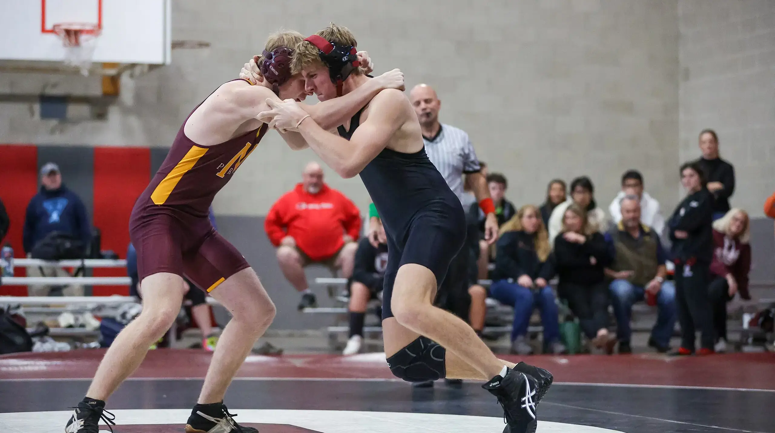 Two boys grappling in a wrestling match.